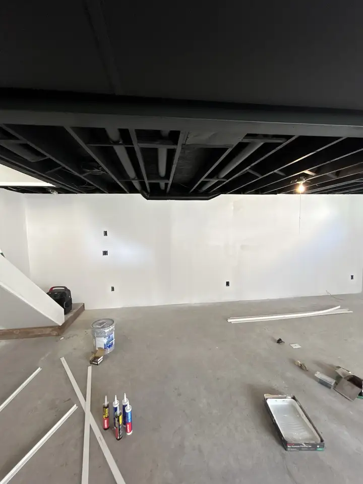 Basement with black open ceiling and new walls